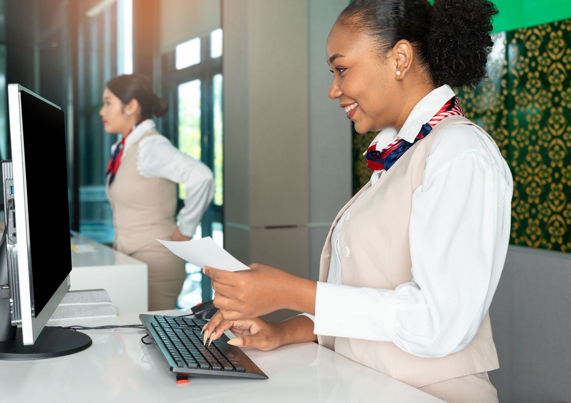 Female african officer working at airline check in service counter airport