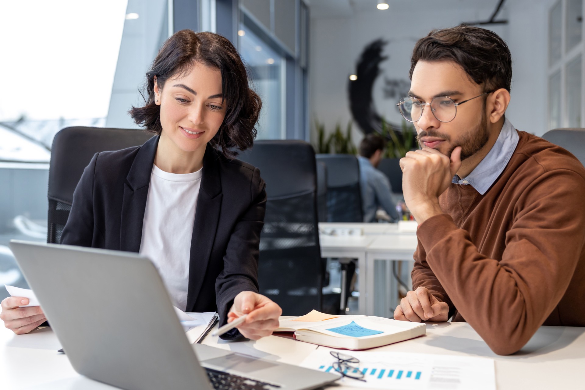Executive colleagues using laptop for creating new business project sitting in office