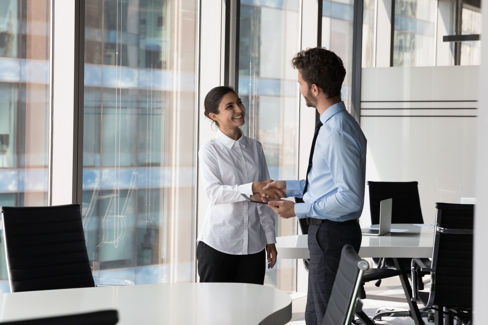 Two diverse confident business man and woman shaking hands